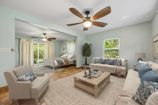 a living room with furniture a large window and a chandelier