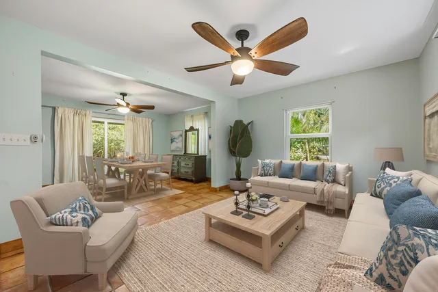 a living room with furniture a large window and a table