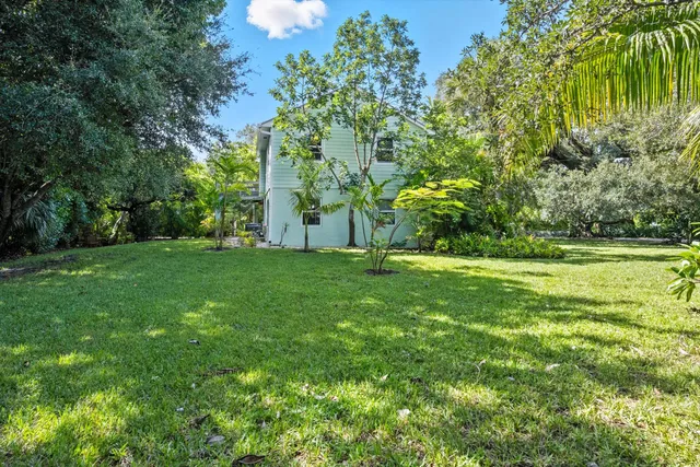a view of a house with a big yard and potted plants