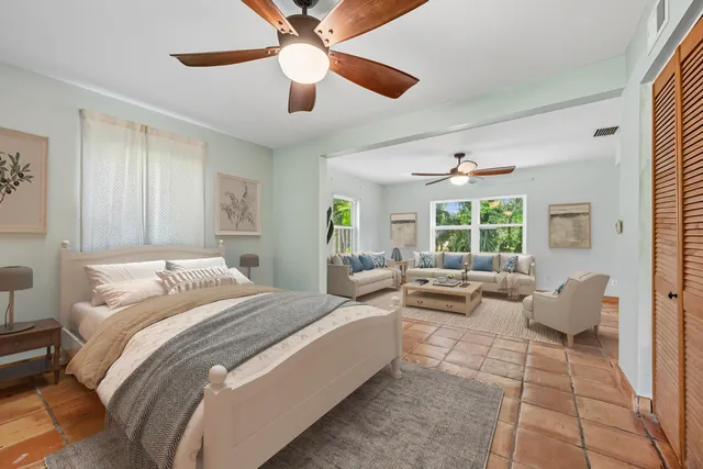 a spacious bedroom with a bed and glass windows