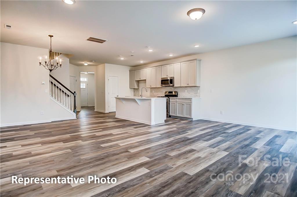 2153 Bexar Trail Matthews, NC 28105 - Photo 11 of 35 a view of a kitchen with kitchen island a sink wooden floor and stainless steel appliances
