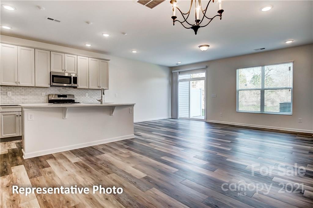 2153 Bexar Trail Matthews, NC 28105 - Photo 12 of 35 a view of kitchen with stainless steel appliances granite countertop a stove top oven a sink dishwasher and a refrigerator with wooden floor