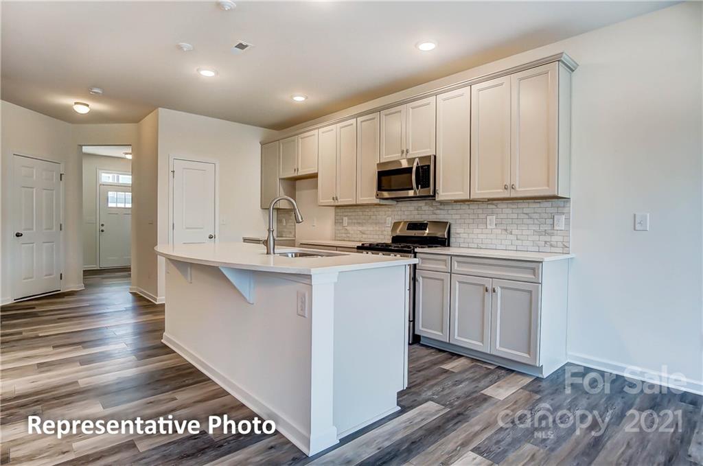 2153 Bexar Trail Matthews, NC 28105 - Photo 14 of 35 a kitchen with stainless steel appliances granite countertop a stove a sink and a microwave