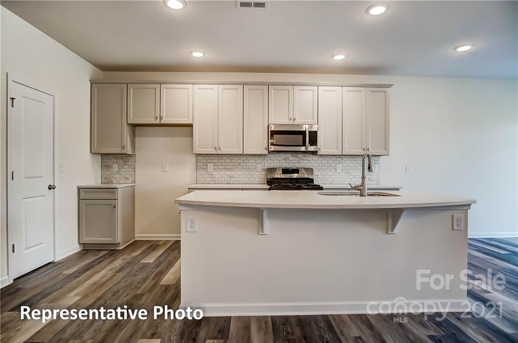 2153 Bexar Trail Matthews, NC 28105 - Photo 15 of 35 a kitchen with stainless steel appliances a sink a stove a refrigerator and cabinets