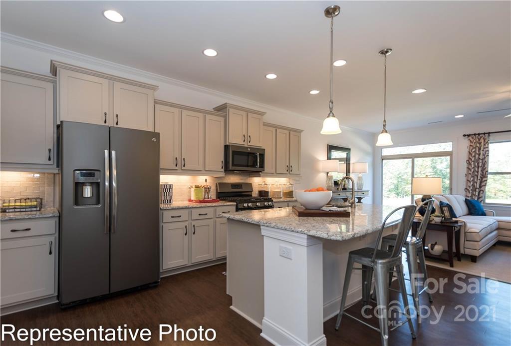 2153 Bexar Trail Matthews, NC 28105 - Photo 20 of 35 a kitchen with stainless steel appliances granite countertop a refrigerator a sink dishwasher a stove and white cabinets with wooden floor