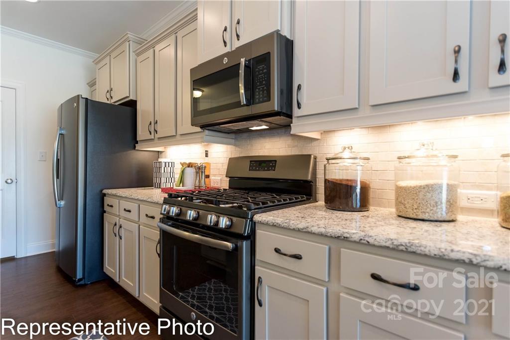 2153 Bexar Trail Matthews, NC 28105 - Photo 23 of 35 a kitchen with stainless steel appliances granite countertop a stove a refrigerator and a microwave