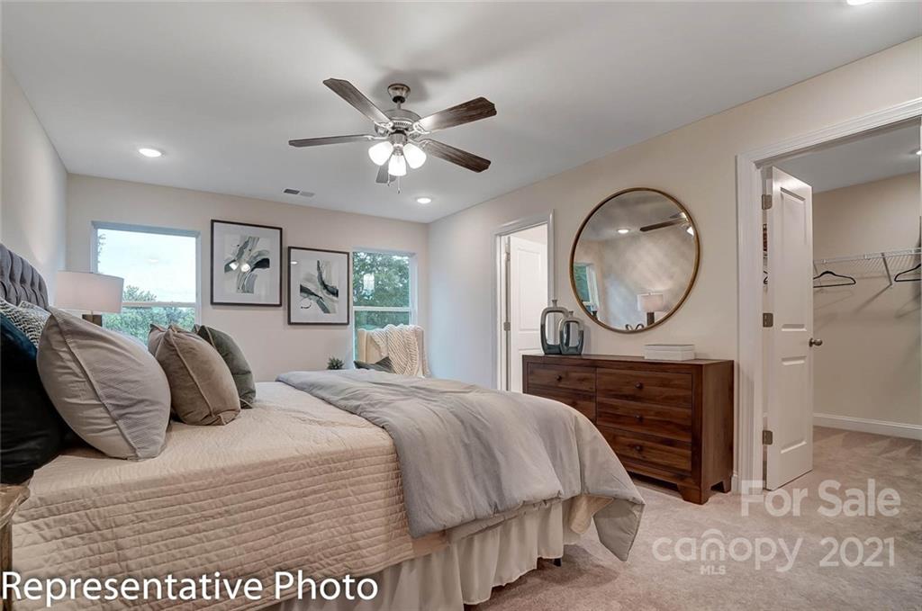 2153 Bexar Trail Matthews, NC 28105 - Photo 27 of 35 a bedroom with a large bed and a chandelier