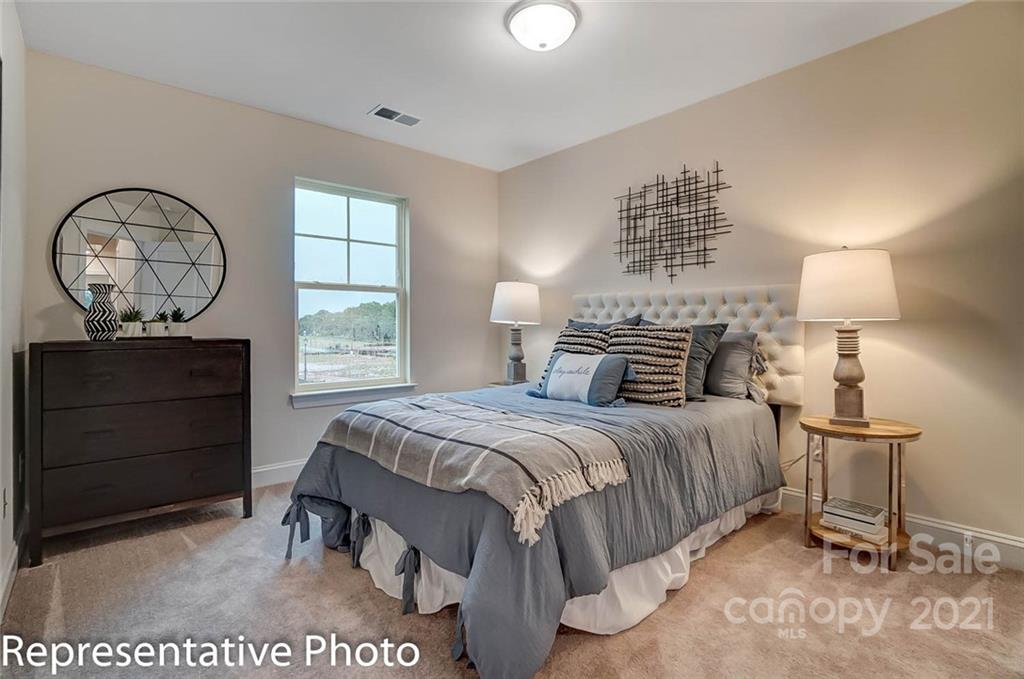 2153 Bexar Trail Matthews, NC 28105 - Photo 33 of 35 a bedroom with a bed a chandelier and a window