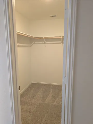 a kitchen with a refrigerator a stove top oven and white cabinets