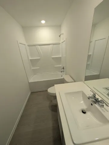 a bathroom with a tub sink and mirror