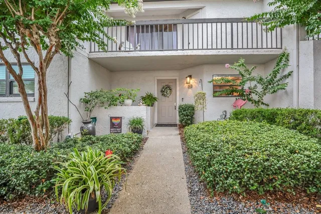a view of a house with brick walls and flower plants