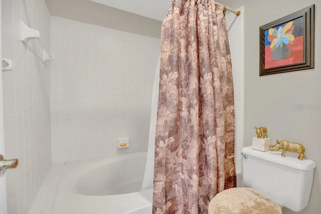 a bathroom with a toilet and a shower curtain