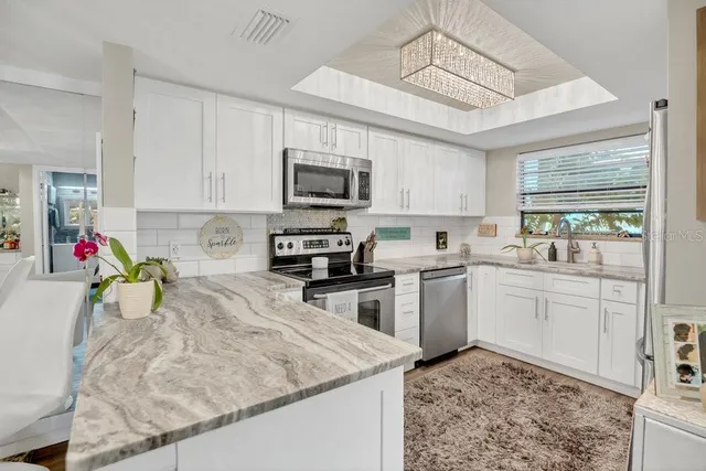 a kitchen that has a lot of cabinets in it and appliances