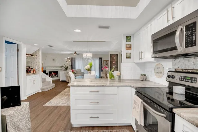 a kitchen with stainless steel appliances kitchen island granite countertop a stove and a sink