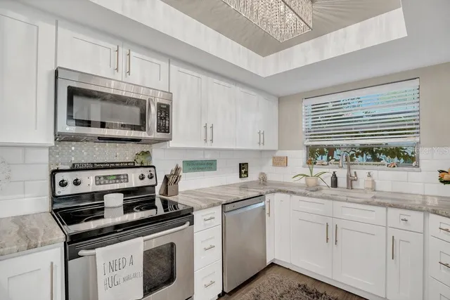a kitchen with cabinets stainless steel appliances and a sink