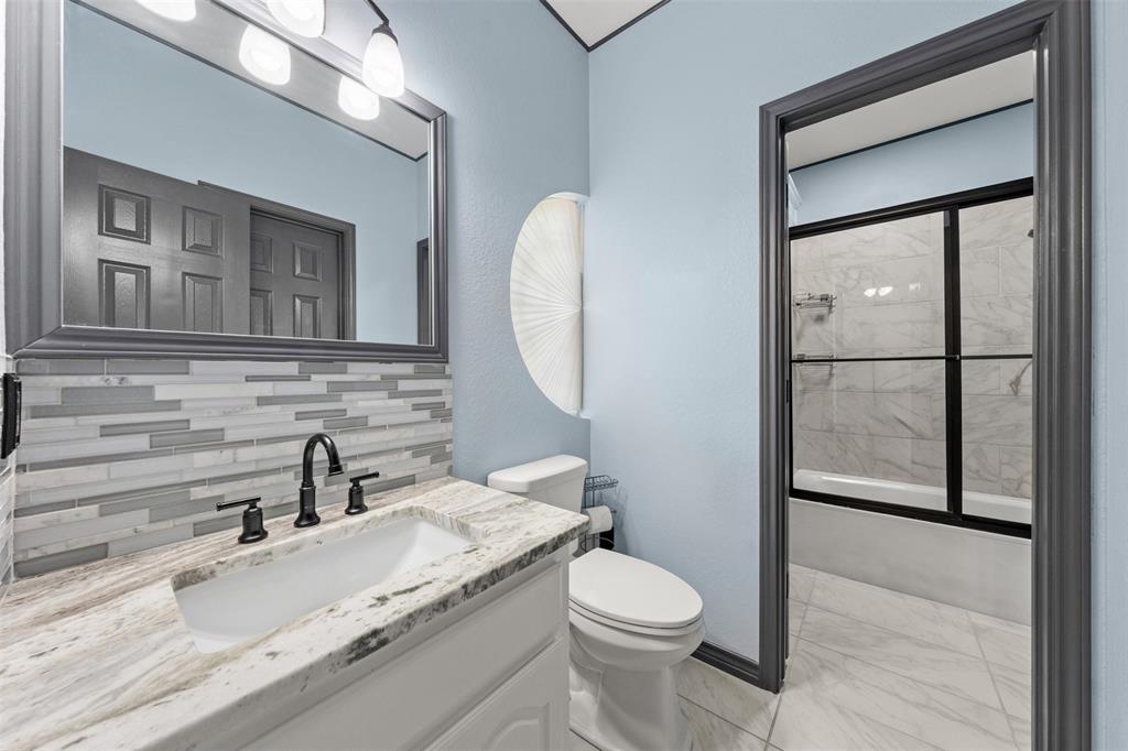 3091 Rockbridge Road McGregor, TX 76657 - Photo 30 of 40 a bathroom with a granite countertop toilet sink and mirror