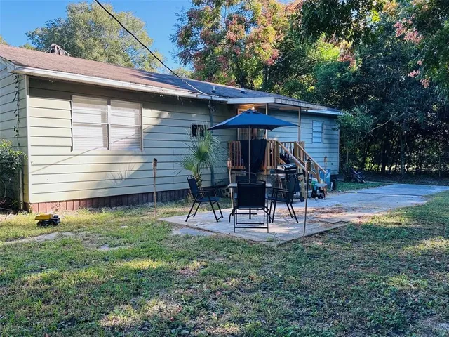 a view of a chair and table in backyard of the house