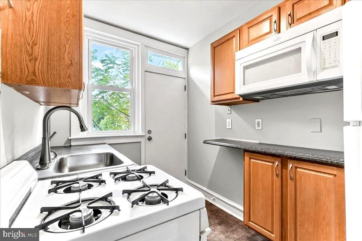 856 Chester Pike, Unit B Sharon Hill, PA 19079 - Photo 8 of 16 a kitchen with a stove a sink and a window