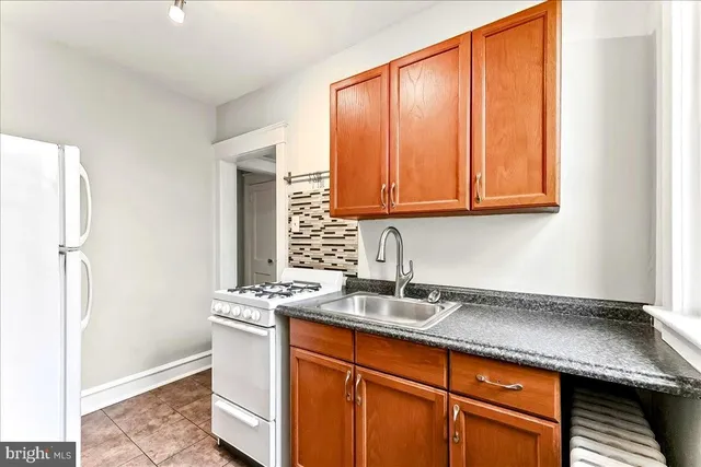 a kitchen with stainless steel appliances granite countertop a sink and a refrigerator