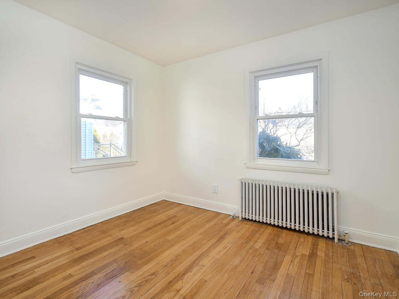47 Edgewood Road Port Washington, NY 11050 - Photo 11 of 22 an empty room with wooden floor and windows