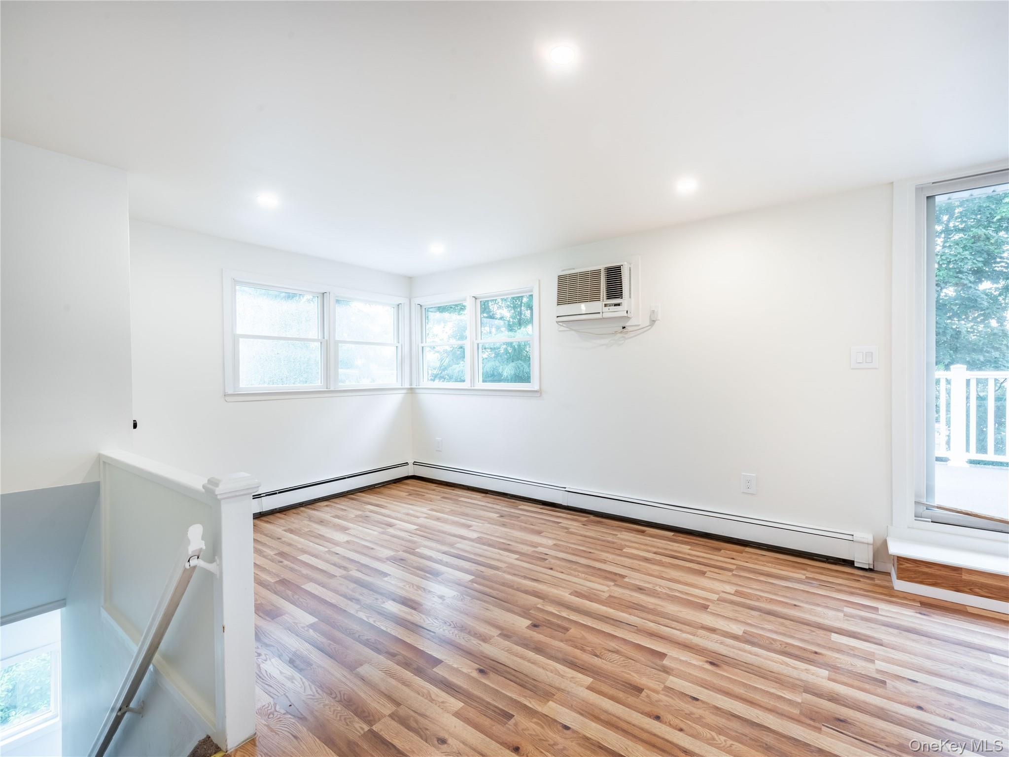 47 Edgewood Road Port Washington, NY 11050 - Photo 17 of 22 an empty room with wooden floor and windows