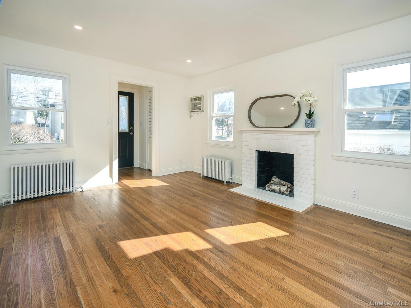 47 Edgewood Road Port Washington, NY 11050 - Photo 3 of 22 a view of an empty room with wooden floor fireplace and a window