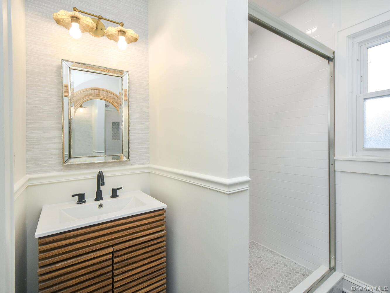 47 Edgewood Road Port Washington, NY 11050 - Photo 7 of 22 a bathroom with a sink a mirror and a window