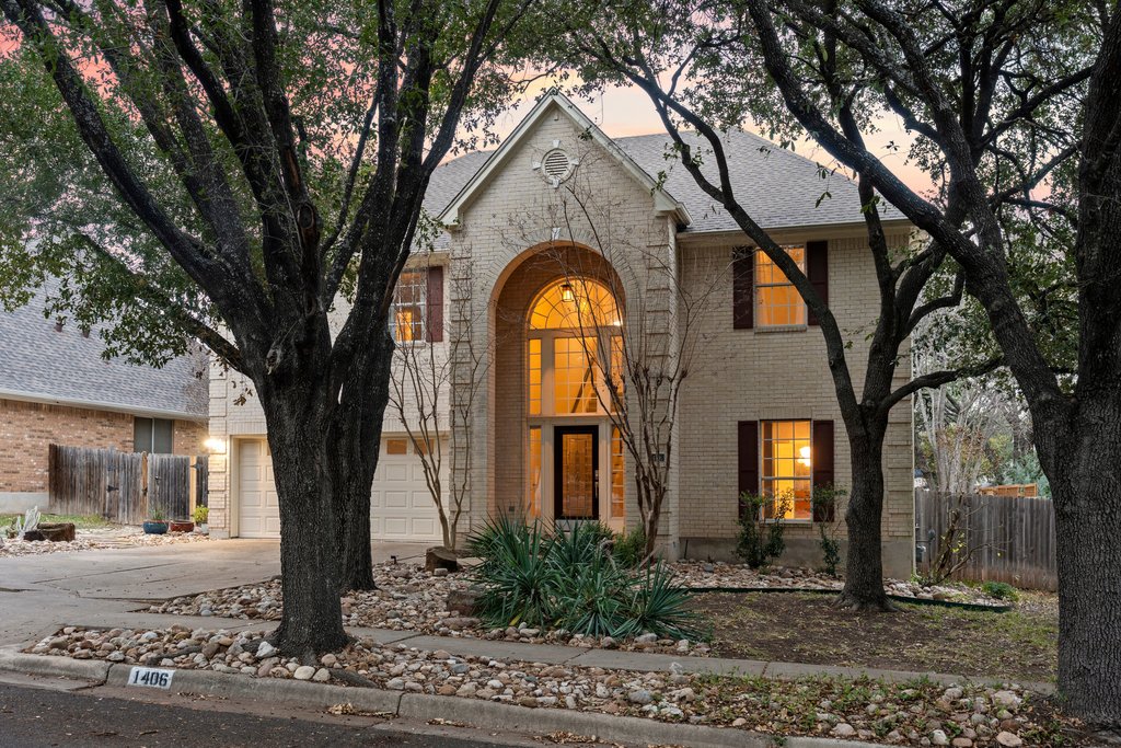 View of front facade with brick siding and driveway