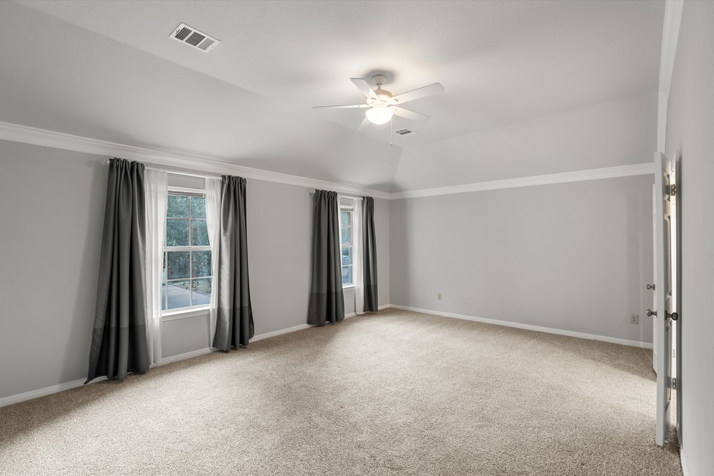 1406 Dapplegrey Lane Austin, TX 78727 - Photo 14 of 38 Spare room featuring ceiling fan, light carpet, crown molding, and vaulted ceiling