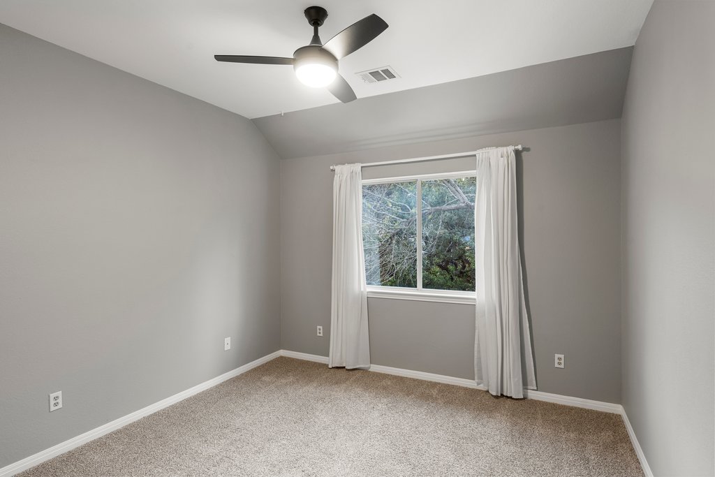 1406 Dapplegrey Lane Austin, TX 78727 - Photo 24 of 38 Spare room featuring vaulted ceiling, light colored carpet, and a ceiling fan