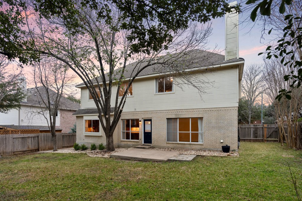 1406 Dapplegrey Lane Austin, TX 78727 - Photo 26 of 38 Rear view of house featuring a patio, a chimney, brick siding, and a fenced backyard