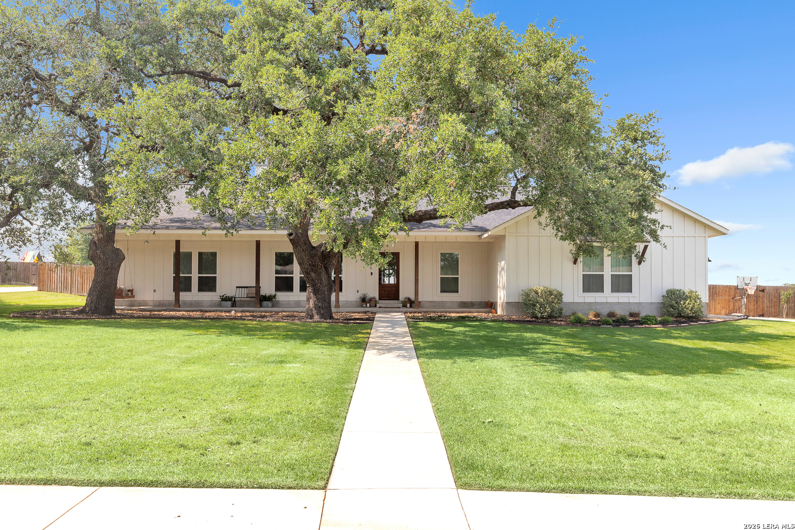 a view of a house with a backyard and a tree