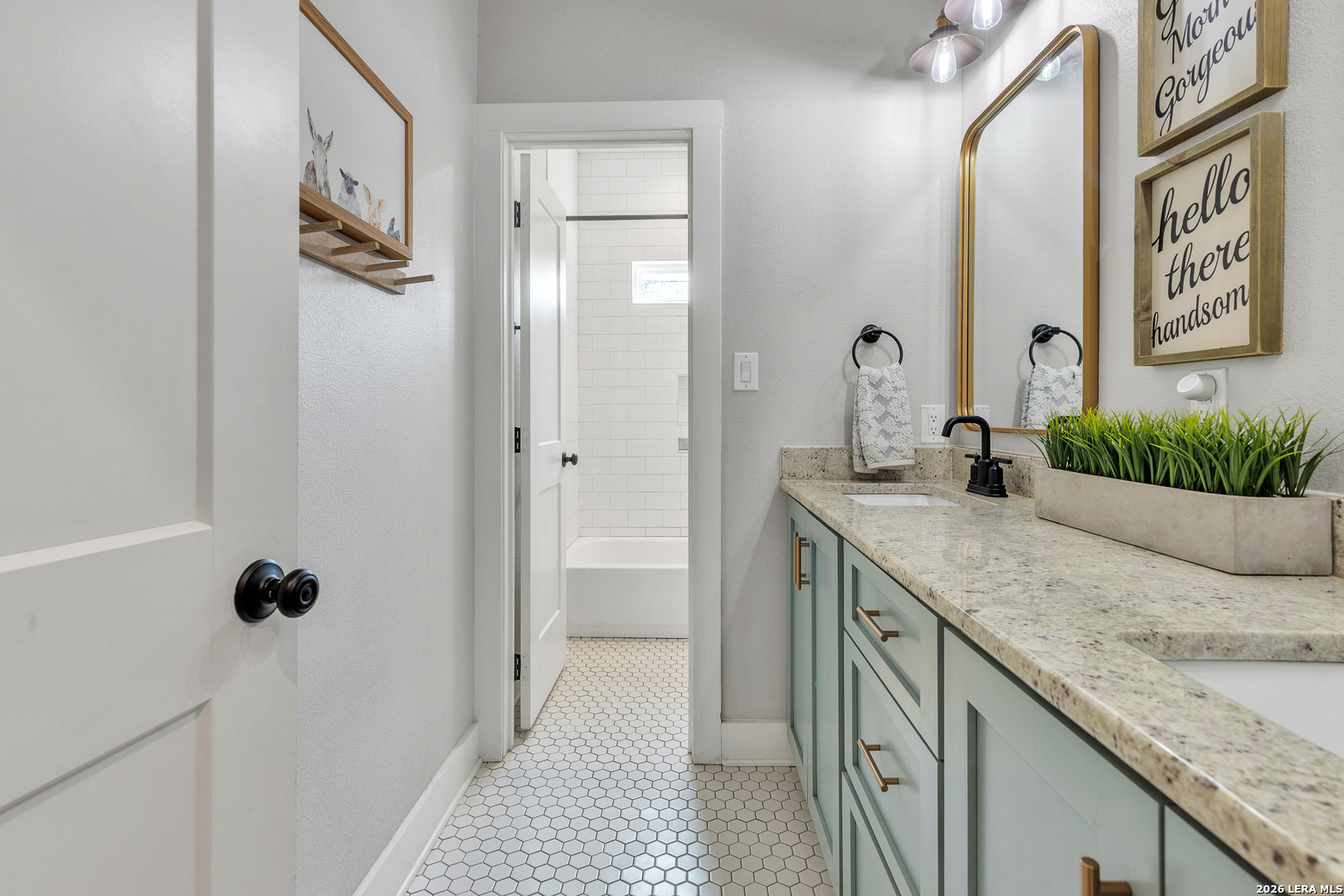 1026 Timbercrest Pleasanton, TX 78064 - Photo 21 of 37 a bathroom with a granite countertop sink a mirror a vanity and a shower