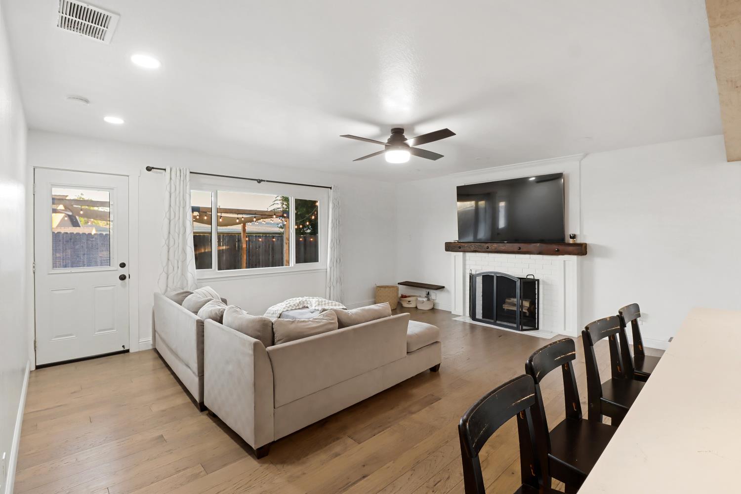 5208 Rambler Way Sacramento, CA 95841 - Photo 14 of 51 a living room with furniture a fireplace and a flat screen tv