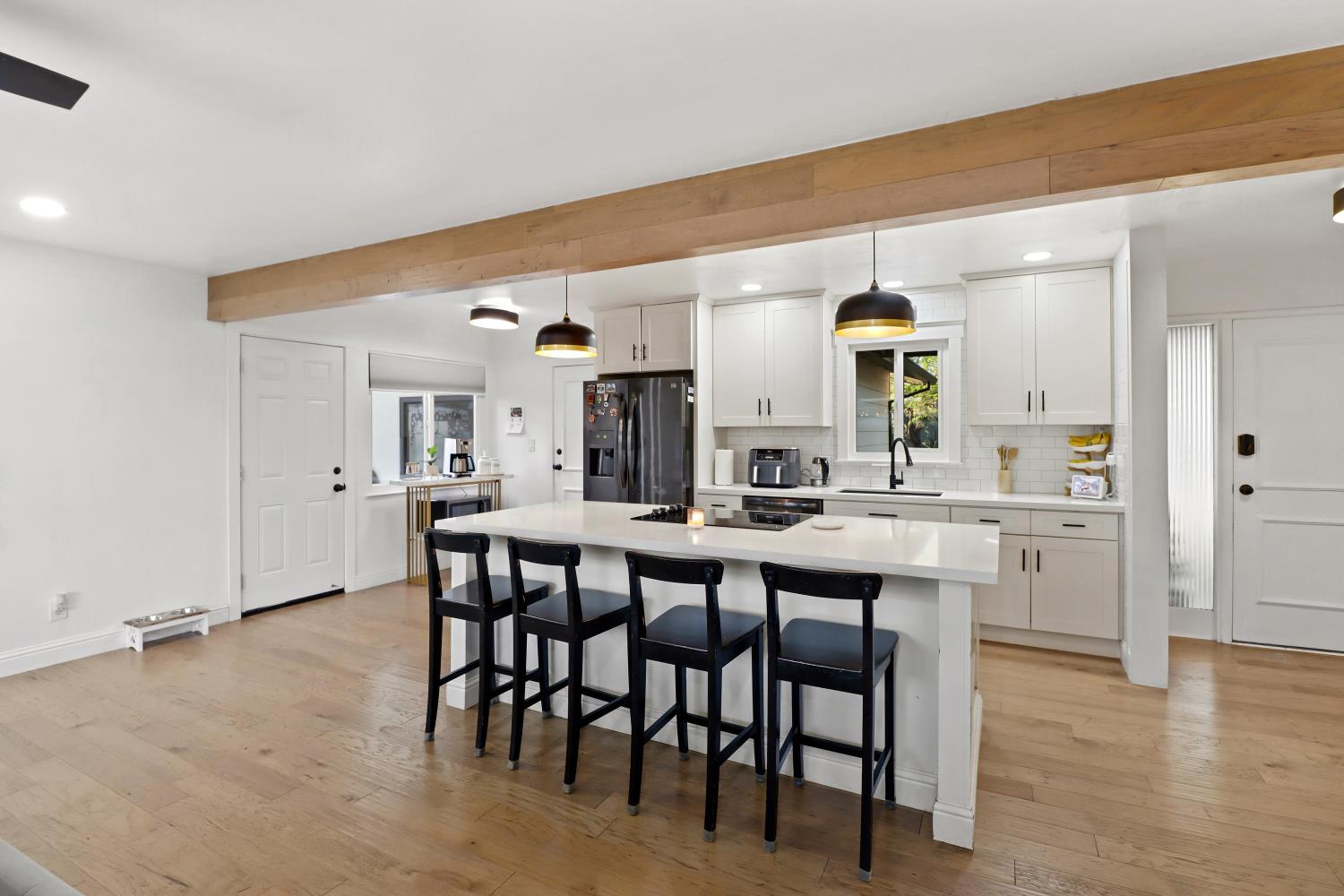 5208 Rambler Way Sacramento, CA 95841 - Photo 21 of 51 a kitchen with a dining table chairs and white cabinets