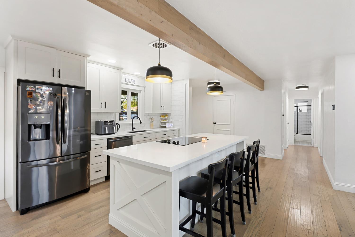 5208 Rambler Way Sacramento, CA 95841 - Photo 23 of 51 a kitchen with stainless steel appliances a refrigerator a stove a sink and white cabinets with wooden floor