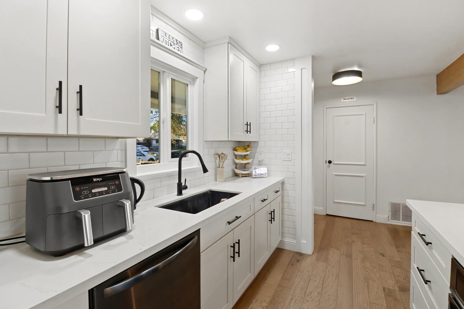 5208 Rambler Way Sacramento, CA 95841 - Photo 26 of 51 a kitchen with a sink cabinets and wooden floor