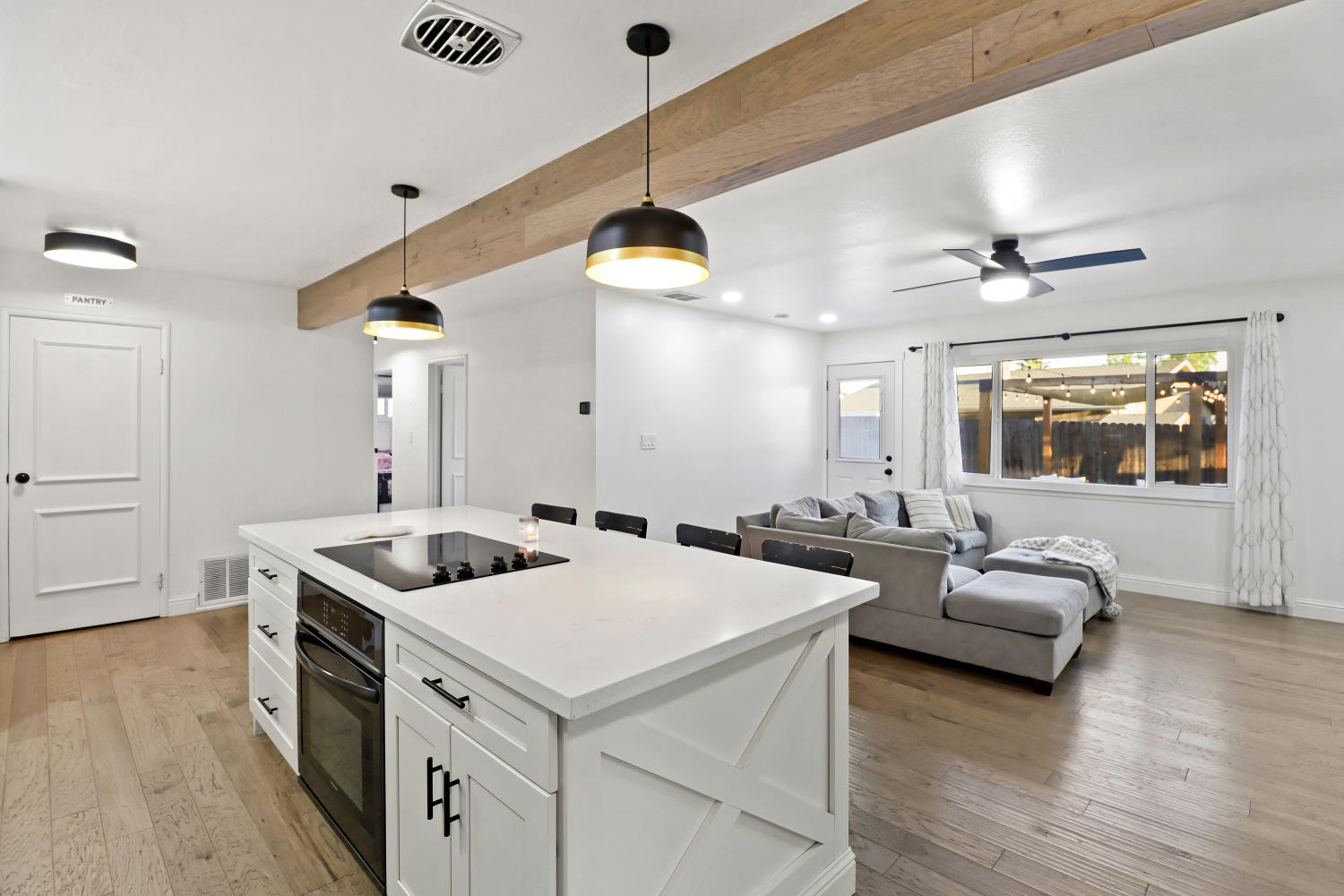 5208 Rambler Way Sacramento, CA 95841 - Photo 27 of 51 a kitchen with a stove and a chandelier
