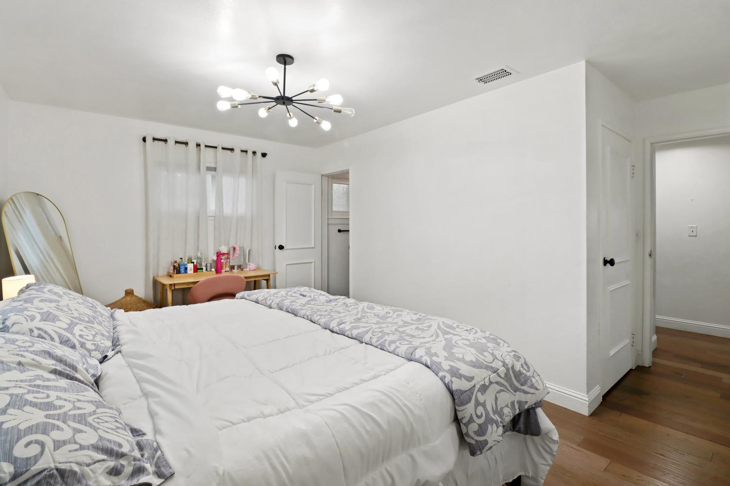 5208 Rambler Way Sacramento, CA 95841 - Photo 32 of 51 a bed room with a bed mirror and a chandelier