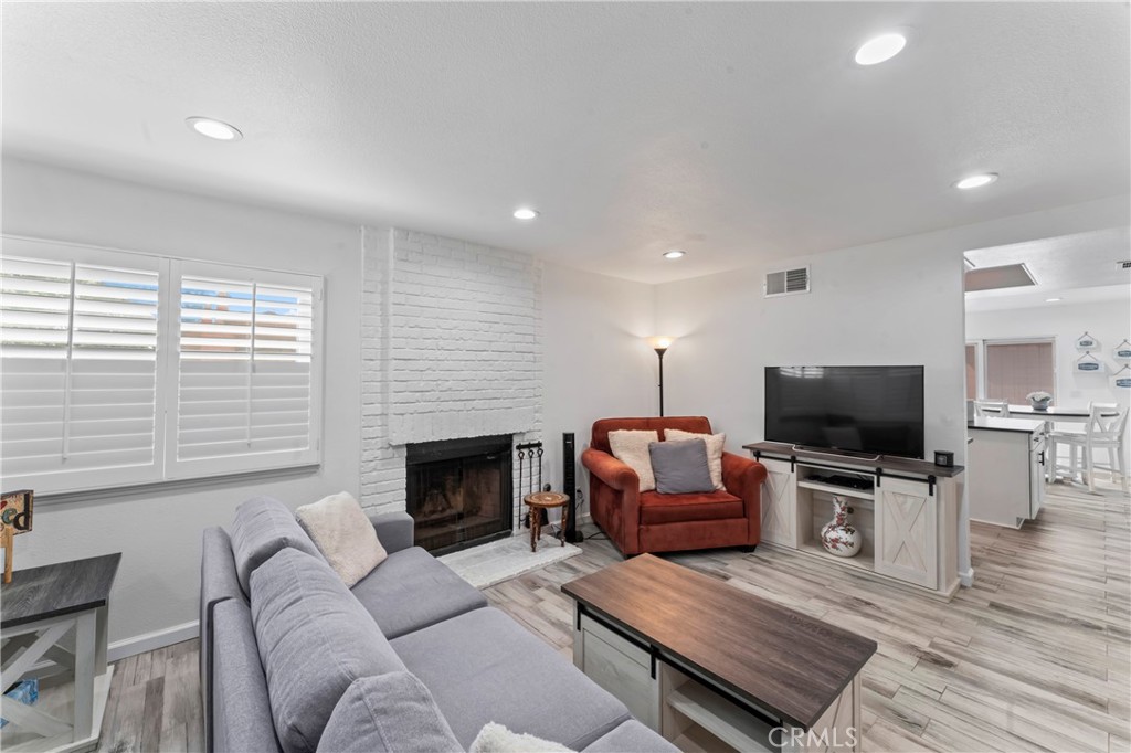 14456 Foothill, Unit 47 Sylmar, CA 91342 - Photo 6 of 26 a living room with furniture a flat screen tv and a fireplace