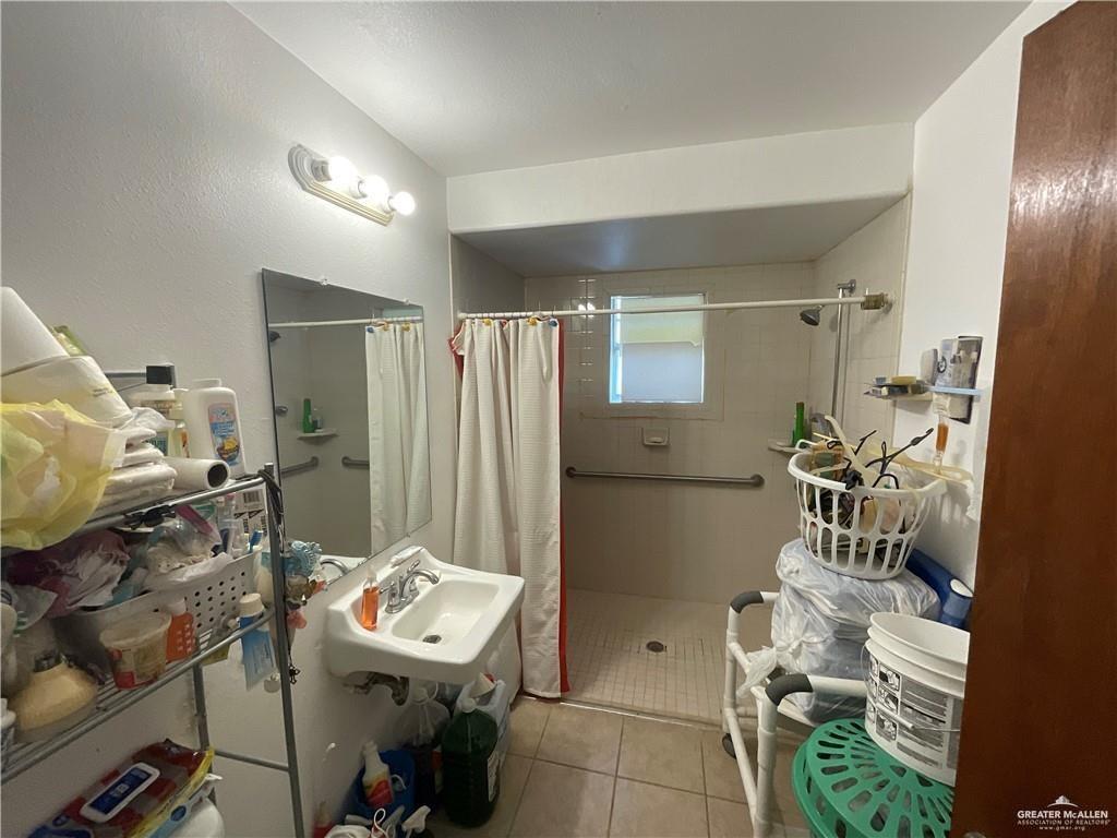 5146 Jm Martinez Street, Unit J Rio Grande City, TX 78582 - Photo 9 of 13 a bathroom with a sink mirror and tub