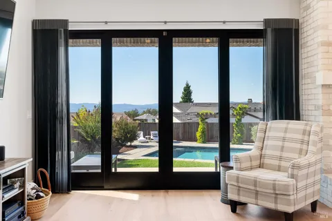 a kitchen with stainless steel appliances kitchen island granite countertop a refrigerator a stove and white cabinets with wooden floor