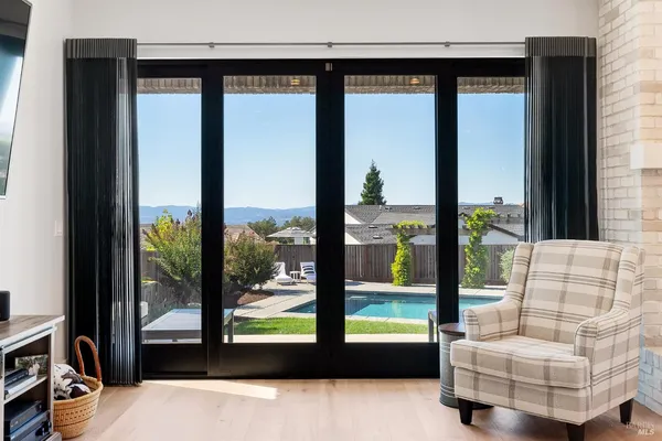 a kitchen with stainless steel appliances kitchen island granite countertop a refrigerator a stove and white cabinets with wooden floor