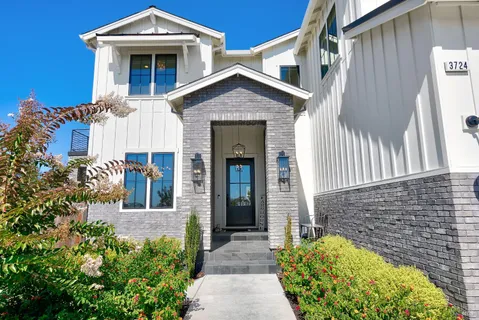 a living room with furniture a chandelier and a flat screen tv
