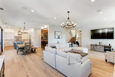 a living room with furniture a fireplace and a chandelier