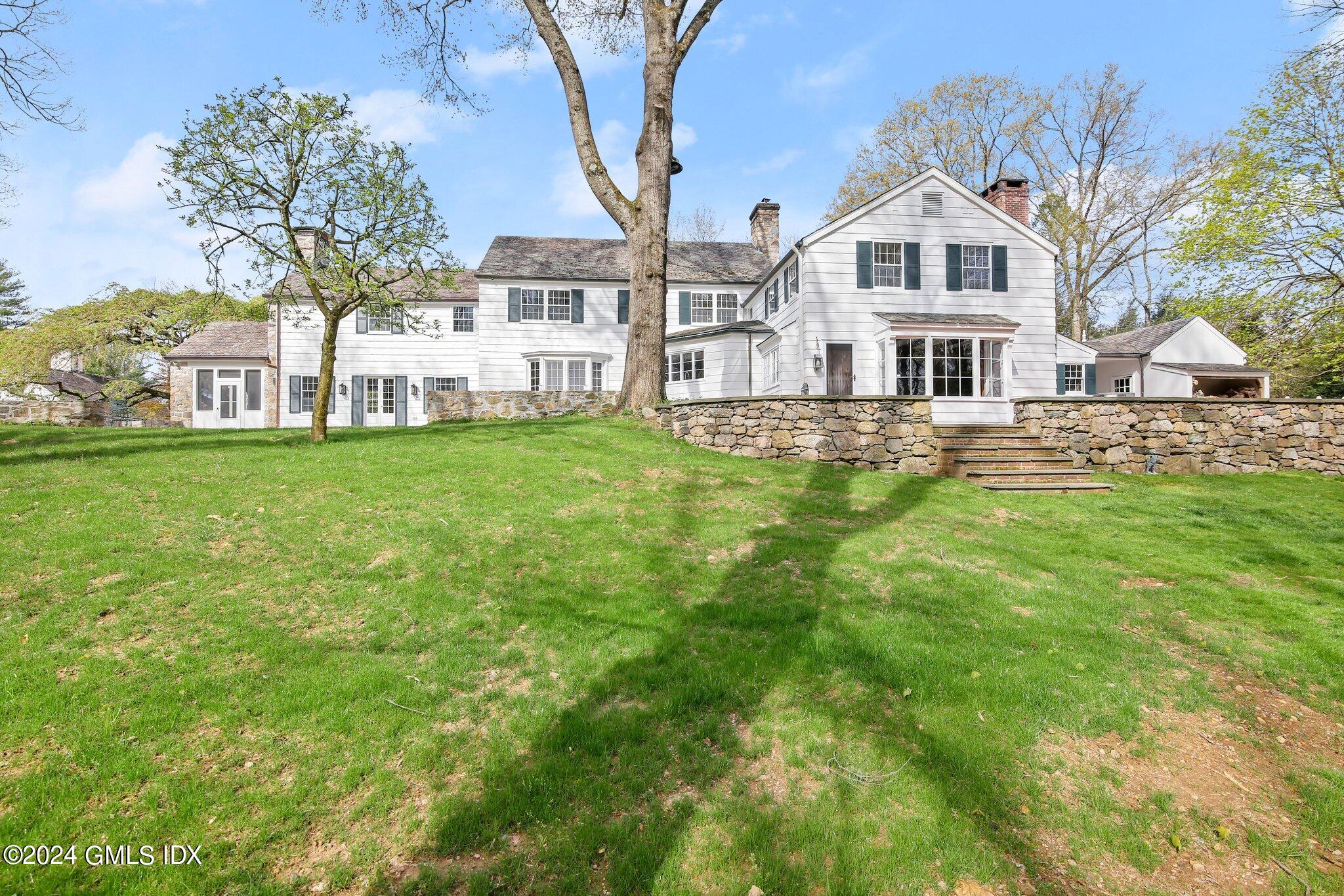 69 Clapboard Ridge Road Greenwich, CT 06830 - Photo 2 of 40 a front view of a house with a yard