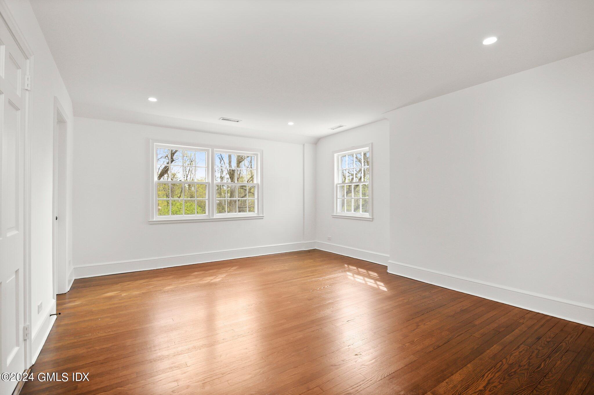 69 Clapboard Ridge Road Greenwich, CT 06830 - Photo 22 of 40 an empty room with wooden floor and windows