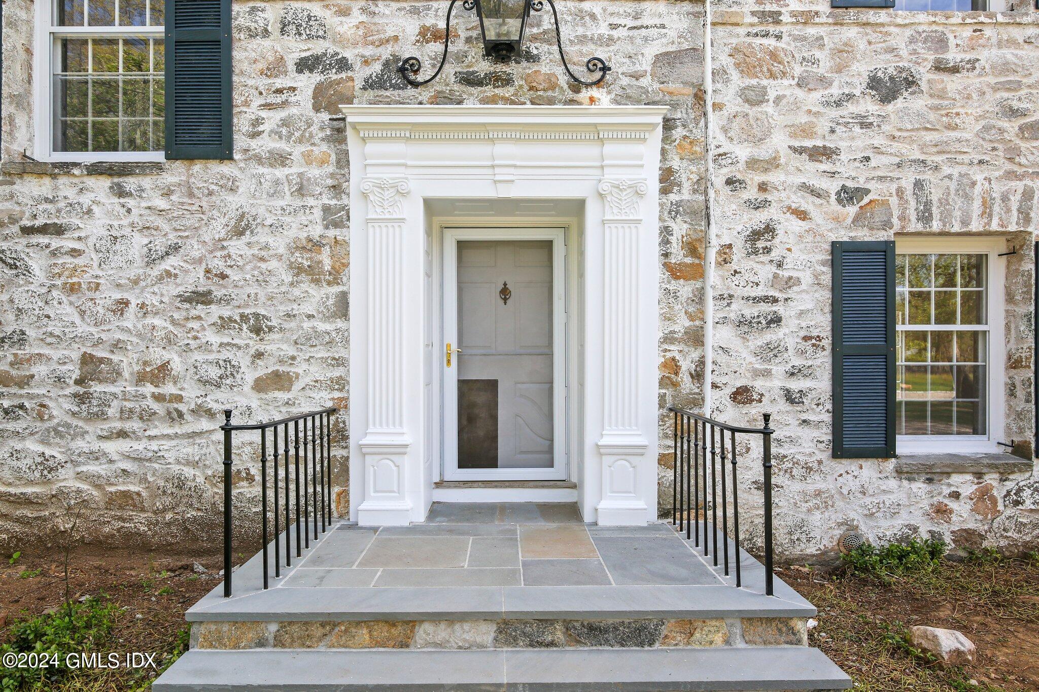 69 Clapboard Ridge Road Greenwich, CT 06830 - Photo 5 of 40 front view of a house with a bench