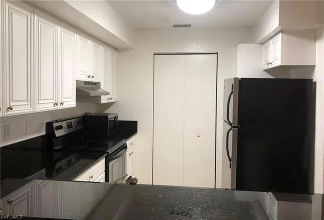 a kitchen with a refrigerator and a sink