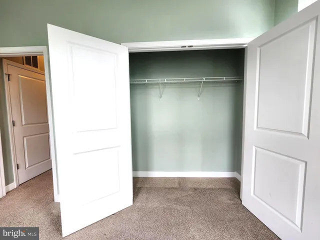 a room with a wooden floor and a refrigerator